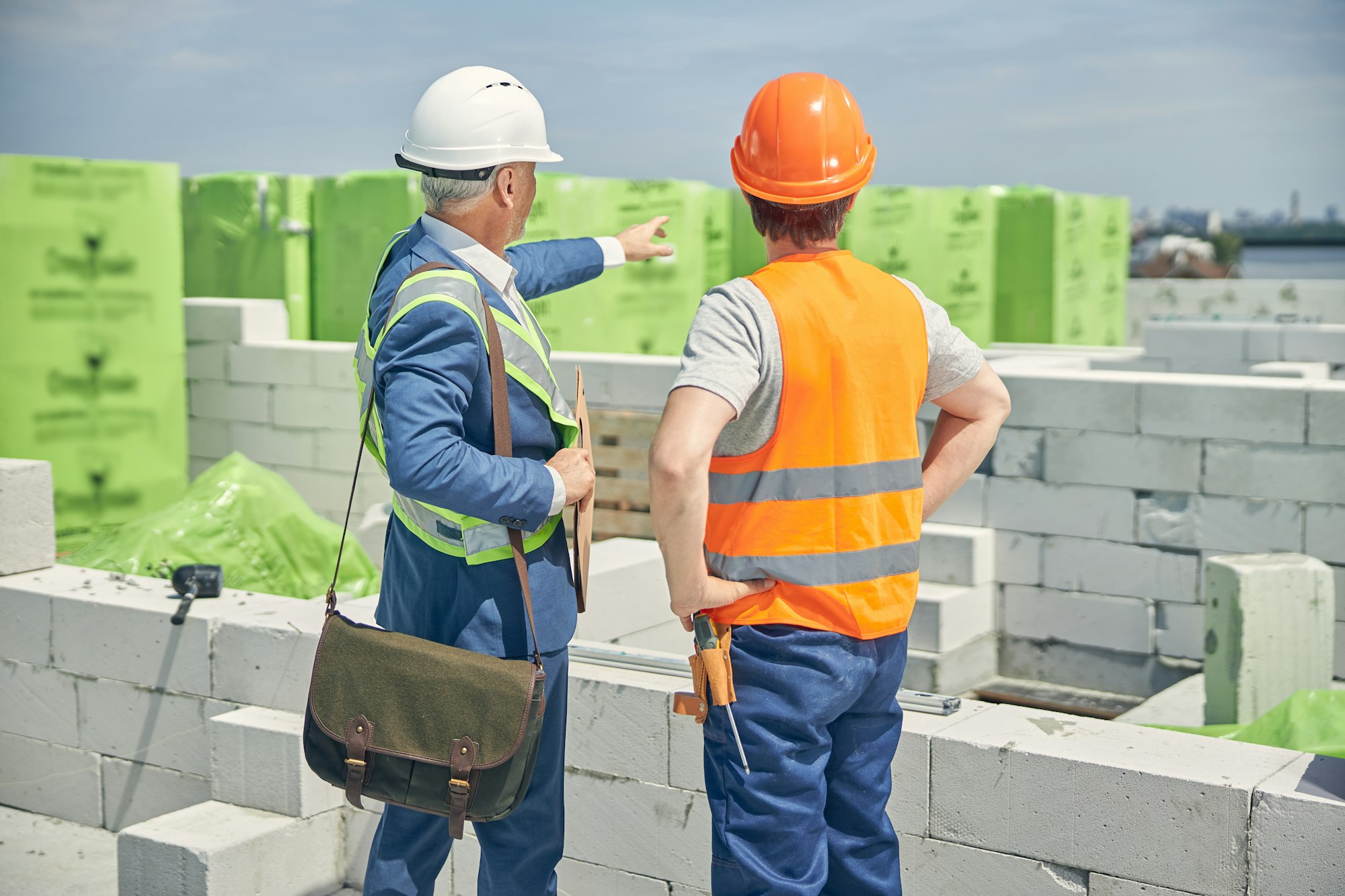 Two Caucasian men inspecting the construction site